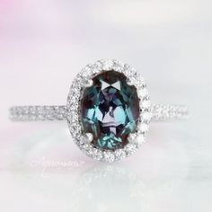 Gorgeous Oval Halo Alexandrite Ring. This classic engagement ring features shimmering scalloped pavé diamonds that extend half of the way around the ring. A diamond halo makes this ring truly spectacular. ►Available in 14K solid white gold. This ring can be also custom made in rose or yellow gold. Metal can be upgraded to 18K at additional cost. ►Matching wedding band can be custom made to order. ►Average band width: 2 mm ►Center stone information Center stone: Alexandrite Stone cut: Oval Gem si Timeless Oval Gemstone Halo Ring, Timeless Oval Halo Ring With Gemstone, Oval Sapphire Emerald Ring With Halo Setting, Classic Oval Halo Ring For Proposal, Classic Anniversary Topaz Ring With Halo, Classic Halo Topaz Ring For Anniversary, Heirloom Oval Halo Ring With Center Stone, Heirloom Style Oval Halo Promise Ring, Timeless Oval Sapphire Wedding Ring