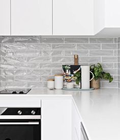 a kitchen with white cabinets and an oven in the center is featured on instagram