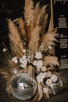 a vase filled with flowers and feathers on top of a table