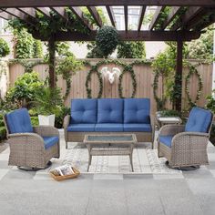 an outdoor living area with blue cushions and wicker furniture