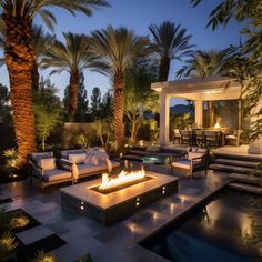 a fire pit in the middle of a patio surrounded by palm trees