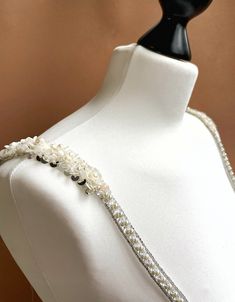 a white dress with pearls and beads on it