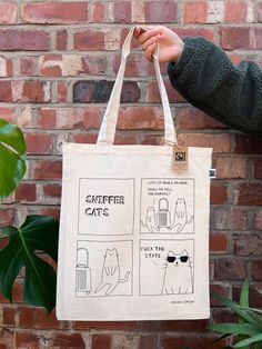 a person holding up a bag with instructions on the front and side, in front of a brick wall