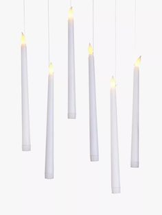 five white candles are hanging from the ceiling