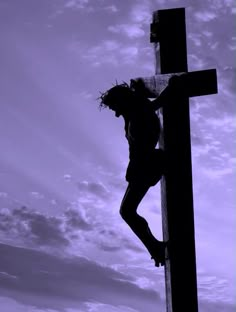 a man climbing up the side of a wooden cross