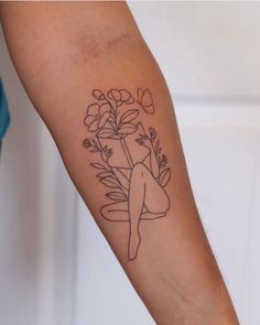 a woman's arm with flowers and a vase on the left side of her body