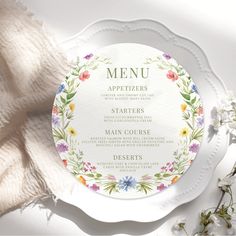 a white plate topped with a menu covered in flowers