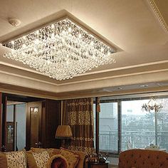 a living room filled with furniture and a chandelier hanging from the ceiling above