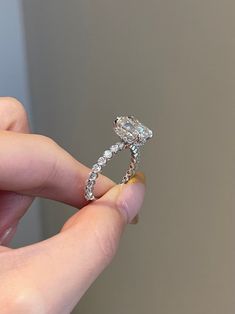 a person holding a diamond ring in their hand