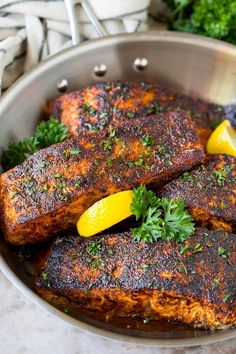 two pieces of meat in a pan with lemons and parsley