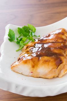 a white plate topped with meat covered in sauce