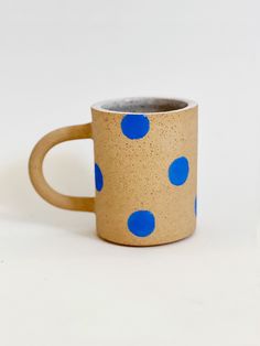 a coffee mug with blue polka dots on it