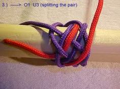 an orange and purple knot is attached to a white piece of cloth with red thread