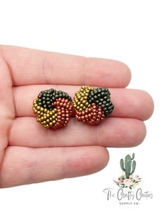 a pair of beaded earrings in the palm of a hand