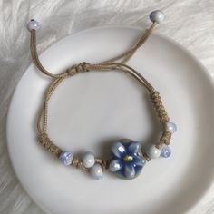 One Costume Jewelry Adjustment String Bracelet. Very Pretty Floral Charm/Bead. Nude/Light Tan String Color. A Lovely Gift. New/Never Used Or Worn. Have A Nice Day! Blue Beaded Bracelets For Spring Gift, Blue Beaded Bracelets As Spring Gift, Casual Blue Flower-shaped Beaded Bracelets, Bohemian Blue Beaded Bracelets For Spring, Blue Bohemian Flower Bracelets, Bohemian Blue Flower Bracelets, Blue Bracelets For Spring, Blue Bohemian Bracelets For Spring, Bohemian Blue Bracelets For Spring