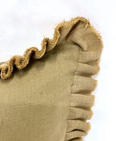 an old pillow with ruffled edges on a white background, showing the bottom part of the cushion