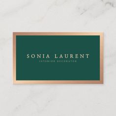 a green and gold business card with the name of an interior decorator on it