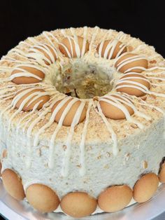 a cake with white icing and balls on it sitting on a platter in front of a black background