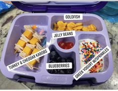 a purple lunch box filled with lots of food