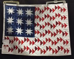 an american flag quilt hanging on a wall