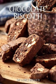 chocolate biscotti on a cutting board with a bowl of cookies in the background