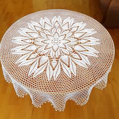 a white doily sitting on top of a wooden floor