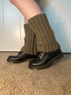 the legs of a person wearing black shoes and socks with knitted leg warmers