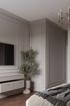 a bedroom with white walls and wood flooring has a large tv on the wall