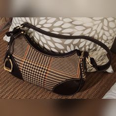 Cute Little Brown Houndstooth Bag. New With Tags Houndstooth Cotton Body With Brown Leather Strap, Trim, Bottom, And Corners Visible Stitching Goldtone Hardware Zipper Closure With A Leather Pull Leather Strap With A 9-Inch Drop Light Tan Polyester Brand Lining Interior One Zipper Pocket With Leather Trim Goldtone Horseshoe Shape Bag Charm On A Leather Strap The Houndstooth Cotton Material Features Vertical A D Horizontal Running Stiched Houndstooth In Orange, Dark Brown, Cream, And Olive. Very Fall Brown Coated Canvas Shoulder Bag, Houndstooth Bag, Drop Light, Visible Stitching, Women's Chaps, Brown Leather Strap, Light Tan, Leather Pulls, Leather Hobo