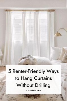 a living room with white furniture and curtains