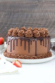 a chocolate cake on a white plate with strawberries