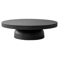 a round table with an oval top and black base, on a white background in front of the camera