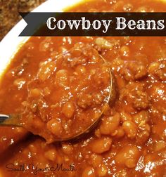 a spoon full of chili beans with the words cowboy beans on it in black lettering