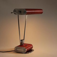 a desk lamp that is on top of a metal stand with a cord attached to it