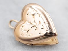 "This beautiful yellow-gold etched heart locket is sure to become a treasured keepsake. Crafted from yellow gold, the intricate detailing creates a lasting impression. Its petite heart shape makes it a perfect gift for a loved one. This pendant does not come with the chain shown. Please feel free to contact us, we will help you find the perfect chain for your style and budget! Metal: 14K Yellow Gold Measurements: 15 x 22 mm, with bail Marks: \"14KT BAB\" Stamped To view a video of this piece check out the link below: https://vimeo.com/834876038 SKU #: A27675 Each piece has been identified and graded by a Graduate Gemologist who has been certified by the Gemological Institute of America (GIA). We have six brick-and-mortar storefronts in Maine, Massachusetts, and New Hampshire and have been Locket Gold, Gold Heart Locket, Gold Locket, Heart Locket, Valentines Gift, Locket Necklace, Gold Heart, Heart Of Gold, Gold Style