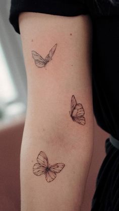 two butterflies on the back of a woman's left arm