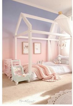 a white canopy bed sitting in a bedroom next to a pink chair and rug on the floor