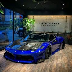 a blue sports car parked in front of a sign