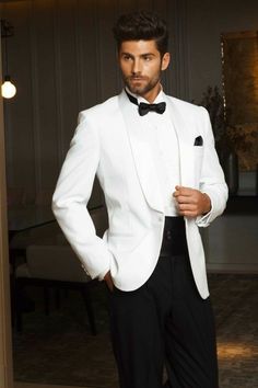 a man in a white tuxedo and black bow tie