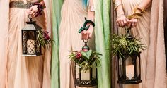 three women in long dresses holding lanterns with plants on them