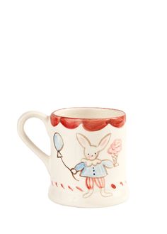 a white mug with an image of a rabbit holding a balloon in it's hand