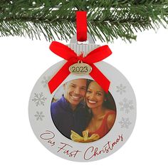 a personalized ornament hanging from a christmas tree with a red ribbon on it