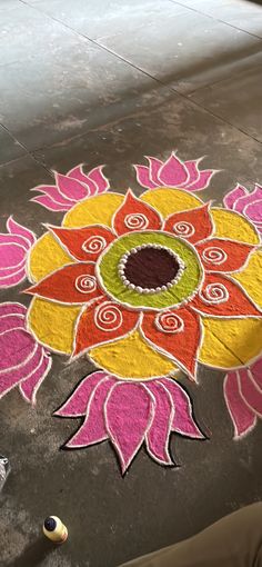 a person standing next to a colorful flower design on the ground