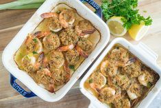 two pans filled with shrimp next to lemon wedges