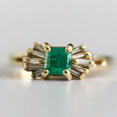 Vintage Ladies 14 Karat Yellow Gold Diamond And Natural Emerald Ring Containing One Square Cut Emerald Measuring 4.65 X 4.59 And Weighing .70 Carats The Emerald Is Described As Light Color And Included With Good Cut And Polish. The Emerald Has A Large Chip On The Girdle Which Extends Into The Crown. Prong Set On Each Side Of The Emerald Are Five Tapered Baguette Shaped Diamonds. Total Weight Of The Ten Tapered Baguettes Is .26 Carats. Diamonds Are Graded H-I In Color And Vs Clarity. Overal Weight Of The Ring Is 2.3 Dwt Ring Size Is 4 1/2 Emerald Cocktail Ring, Emerald Cocktail, Natural Emerald Rings, Square Cut, Natural Emerald, Emerald Ring, Womens Jewelry Rings, Cocktail Rings, Prong Setting