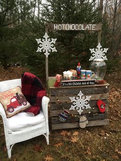 a chair sitting in the grass next to a wooden box with snowflakes on it