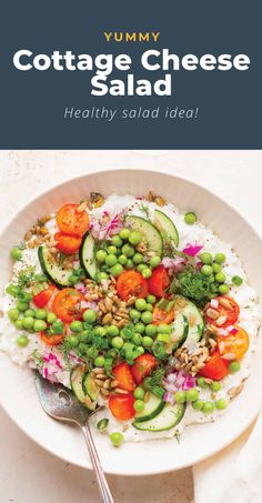 a white bowl filled with vegetables and rice on top of a table next to a fork