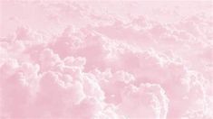 the sky is filled with fluffy clouds and pink hues, as seen from an airplane