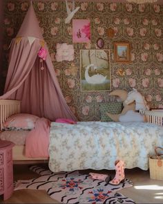 a child's bedroom decorated in pink and green with pictures on the wall, bedding and rugs