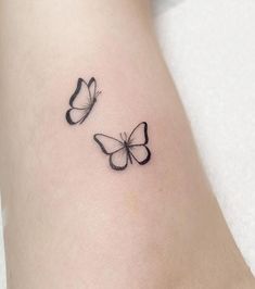 two butterflies tattoo on the left side of the leg, one is black and the other is white